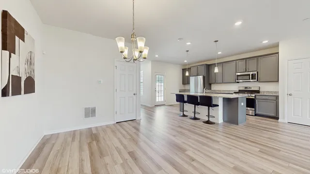 a view of kitchen with refrigerator microwave and wooden floor