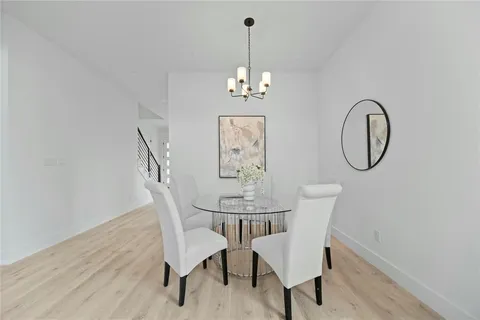 a view of a dining room with furniture a chandelier and wooden floor