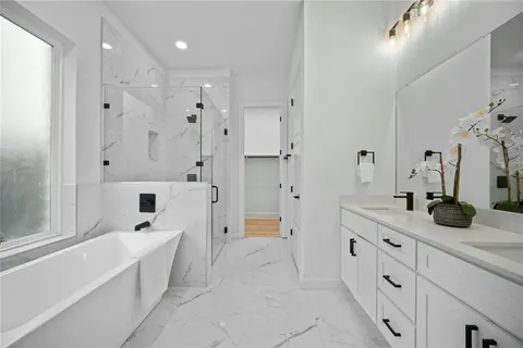 a spacious bathroom with a double vanity sink a mirror a shower and a bathtub