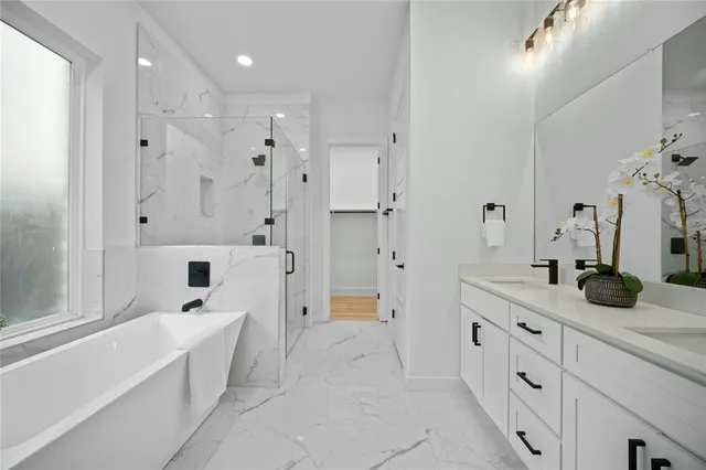 a spacious bathroom with a double vanity sink a mirror a shower and a bathtub