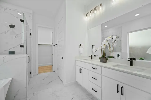 a bathroom with a double vanity sink mirror and shower