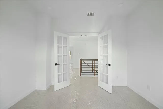 an empty room with a window and a ceiling fan