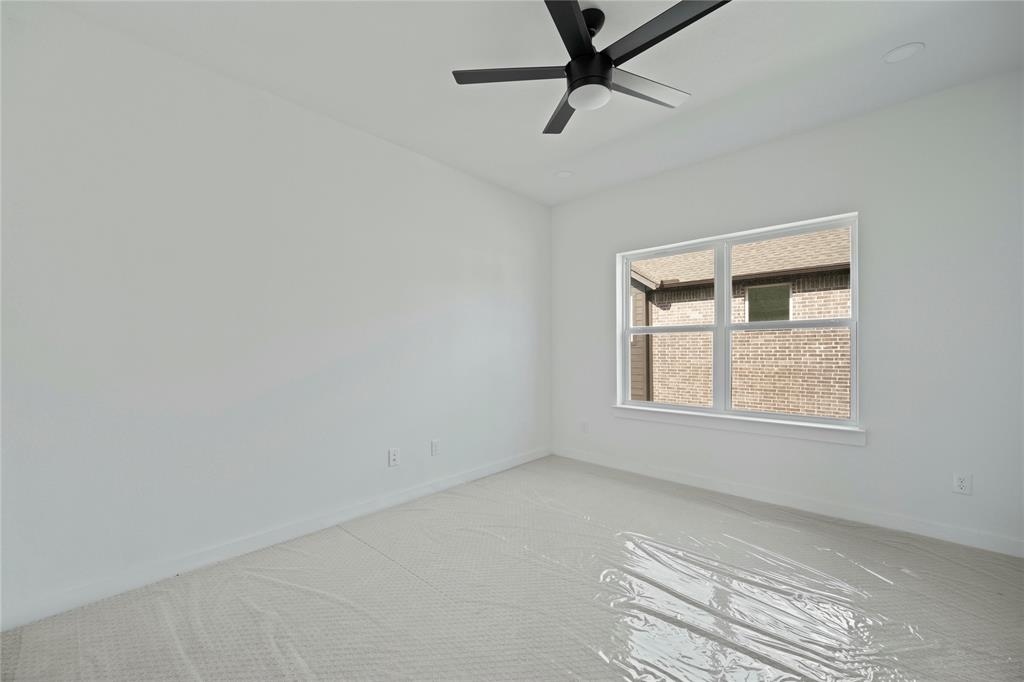 2121 Oak Haven Court Garland, TX 75044 - Photo 29 of 38 an empty room with a window and a ceiling fan