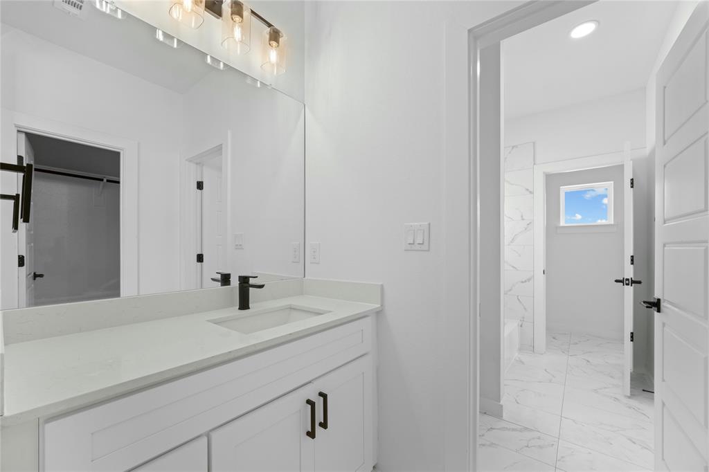 2121 Oak Haven Court Garland, TX 75044 - Photo 31 of 38 a bathroom with a sink and a mirror