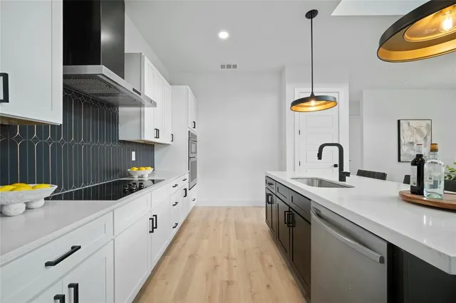 a kitchen with granite countertop a sink stainless steel appliances and cabinets