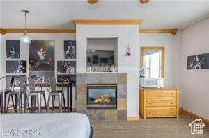 223 Hunter Road, Unit B303 Brian Head, UT 84719 - Photo 9 of 49 Bedroom featuring a tile fireplace and ornamental molding
