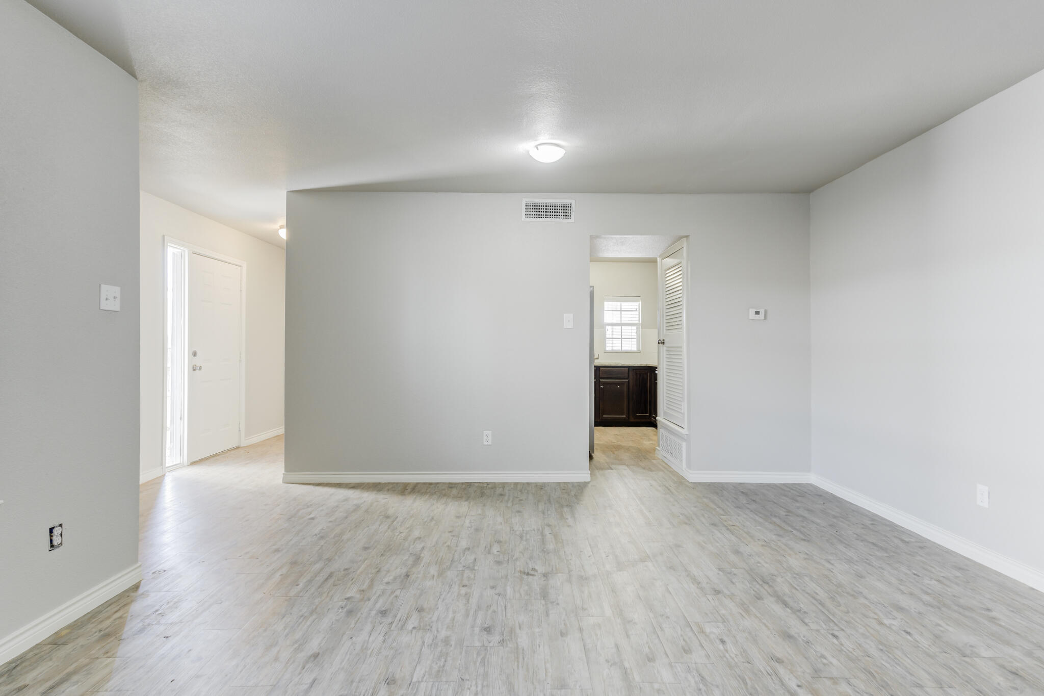 4320 52nd Street Lubbock, TX 79413 - Photo 40 of 59 a view of an empty room with wooden floor and entryway