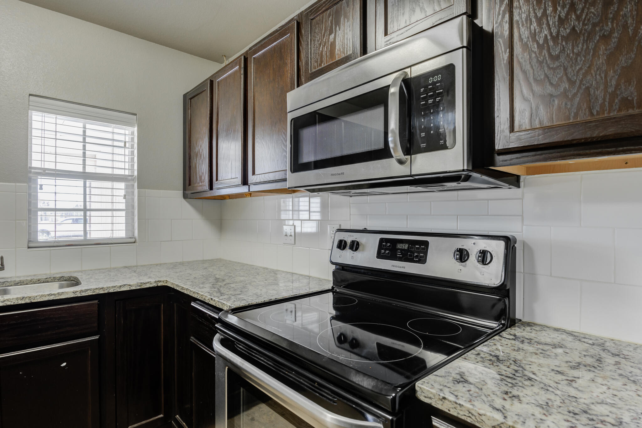 4320 52nd Street Lubbock, TX 79413 - Photo 42 of 59 a kitchen with a stove microwave and sink