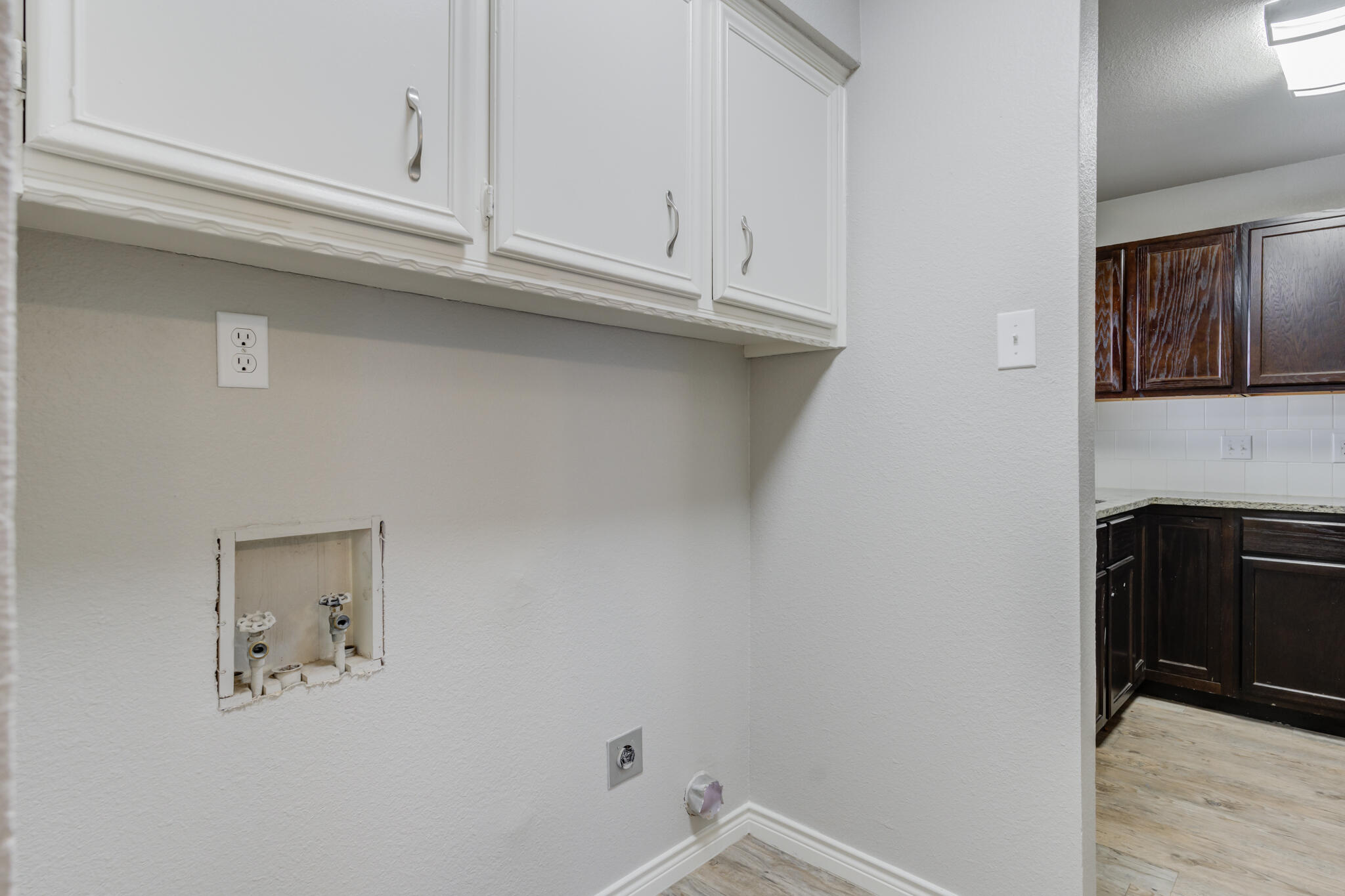 4320 52nd Street Lubbock, TX 79413 - Photo 45 of 59 a kitchen with white cabinets and a wooden floor