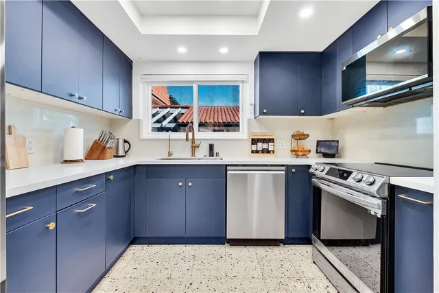 a kitchen with stainless steel appliances granite countertop a sink stove and cabinets