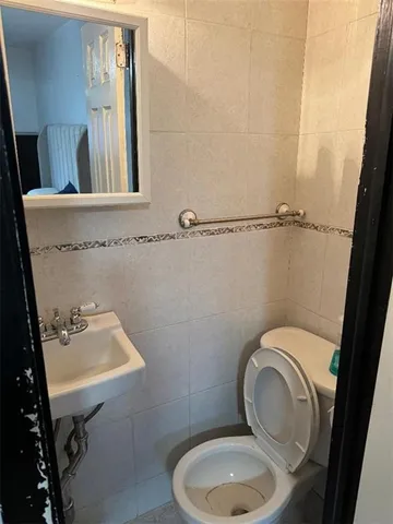a bathroom with a toilet a sink and mirror