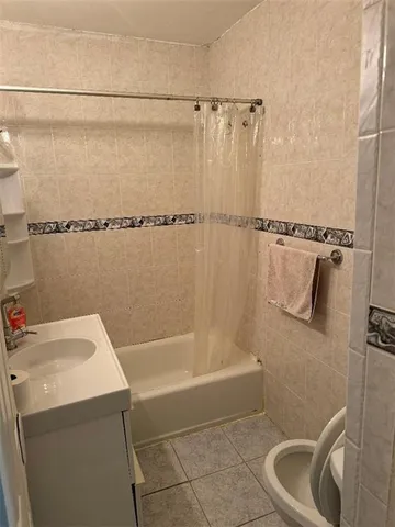 a bath tub sitting next to a white sink and vanity