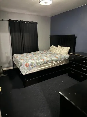 a bed sitting in a bedroom next to a cabinet