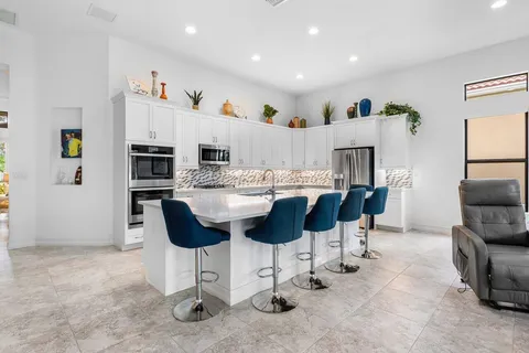 a kitchen with stainless steel appliances kitchen island granite countertop a refrigerator and a stove top oven