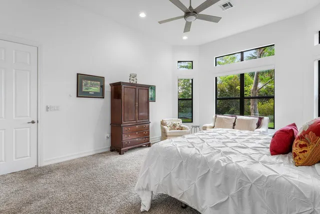 a bedroom with a bed and a large window