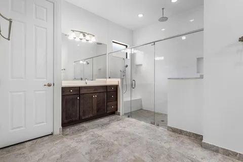 a bathroom with a granite countertop sink a shower and a mirror