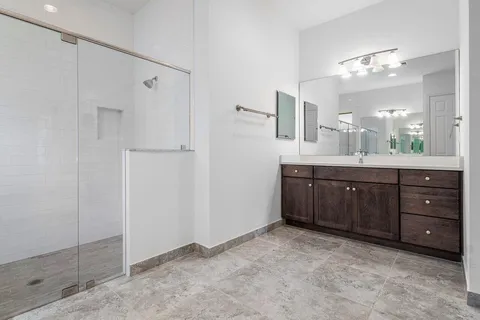 a bathroom with a double vanity sink mirror and shower