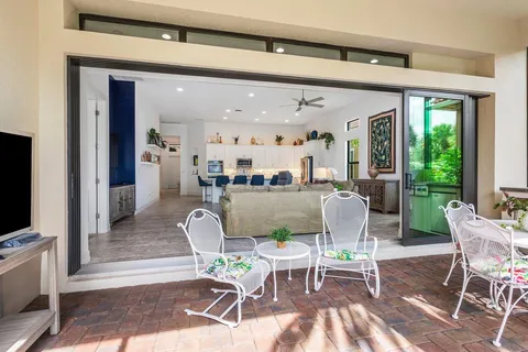 a living room with furniture a flat screen tv and a floor to ceiling window