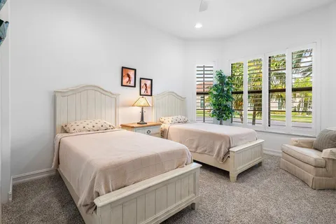 a bedroom with two beds and large window