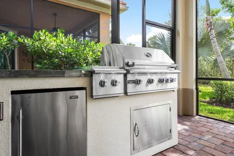a view of a house with a yard patio and a large tree