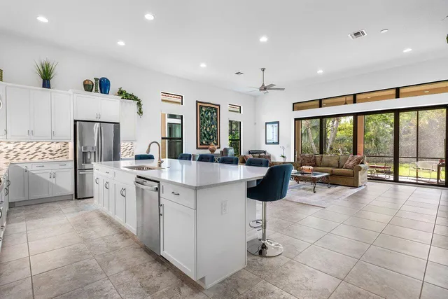 a large kitchen with stainless steel appliances a large counter top a stove and a large window