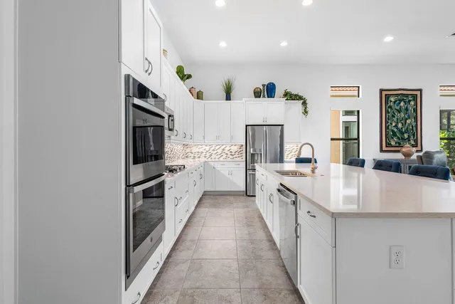 a large white kitchen with stainless steel appliances