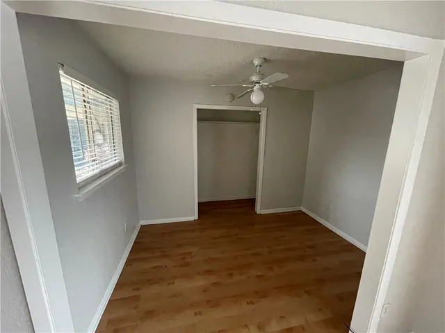 a view of an empty room with closet and a window