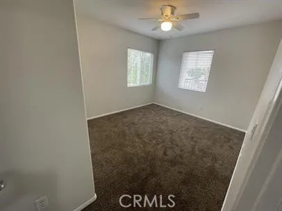 an empty room with closet and a chandelier fan