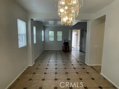 en empty room with windows and chandelier