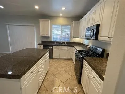 a kitchen with granite countertop a stove and a sink
