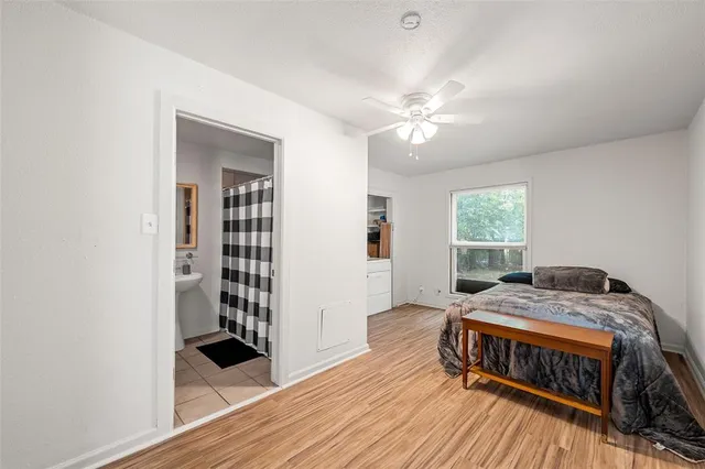a bedroom with a bed and a window with wooden floor