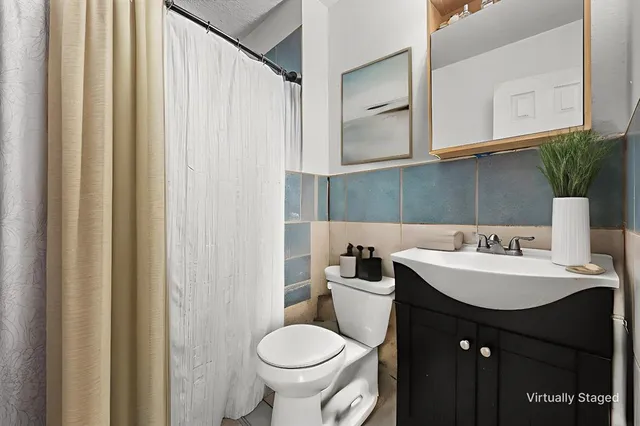 a bathroom with a toilet sink and mirror