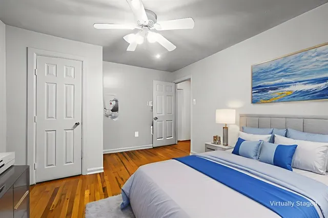 a bedroom with a large bed and ceiling fan
