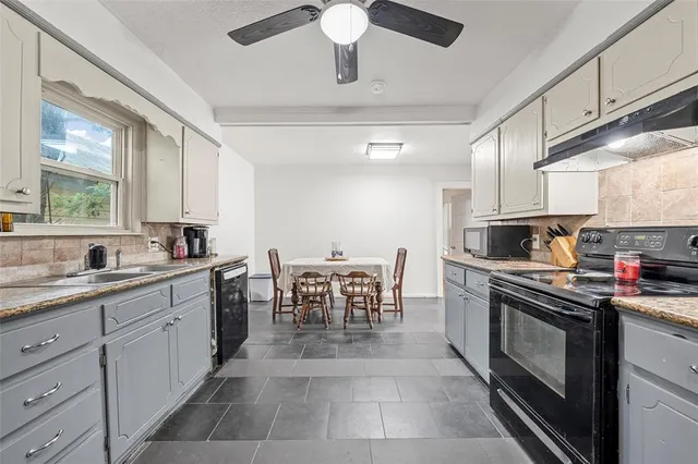 a kitchen with a stove cabinets and chairs
