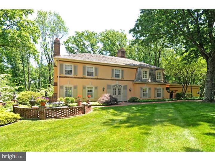 a front view of a house with a garden and trees