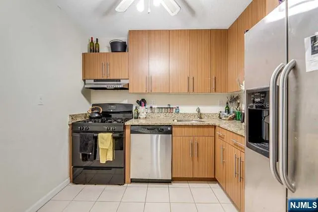 a kitchen with stainless steel appliances granite countertop a stove a sink and a refrigerator