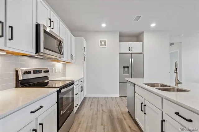 a kitchen with stainless steel appliances a stove microwave and refrigerator
