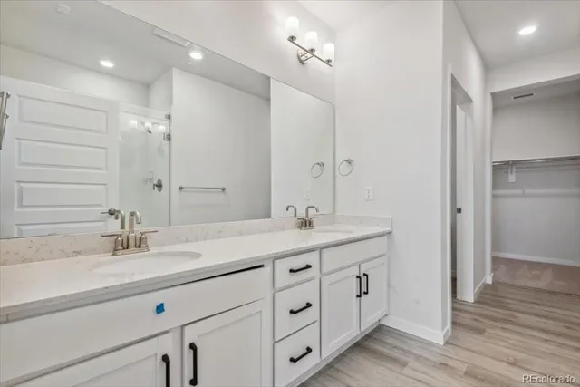 a bathroom with double vanity sink and a mirror