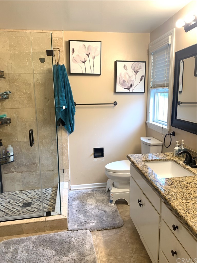 23625 Pineforest Lane Harbor City, CA 90710 - Photo 13 of 22 a bathroom with a granite countertop sink mirror vanity and toilet