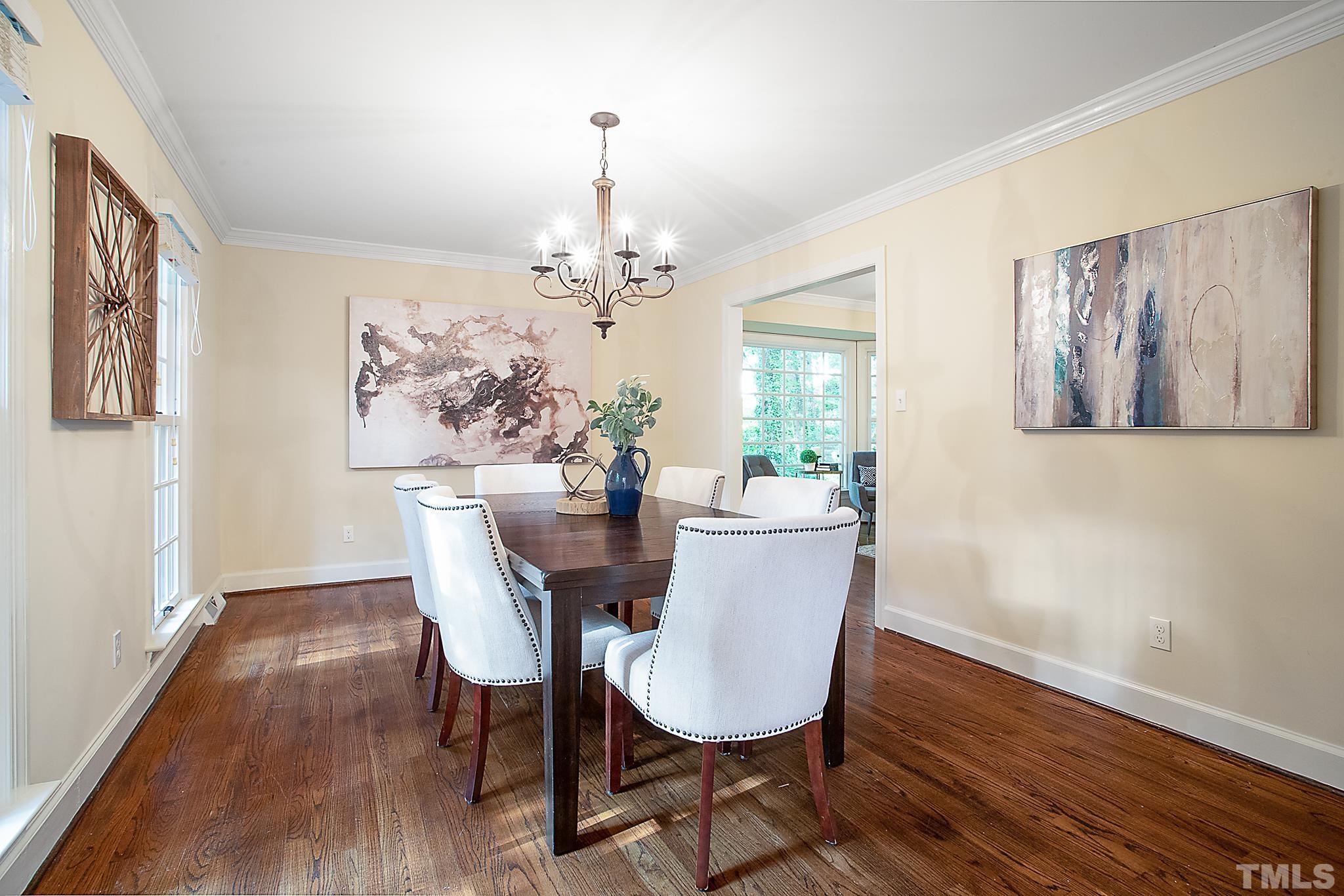 7301 Tanbark Way Raleigh, NC 27615 - Photo 5 of 36 a view of a dining room with furniture wooden floor and a chandelier