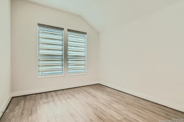 an empty room with wooden floor and a window