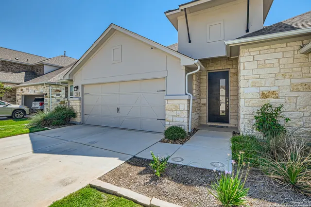 a front view of a house with a yard and a garage