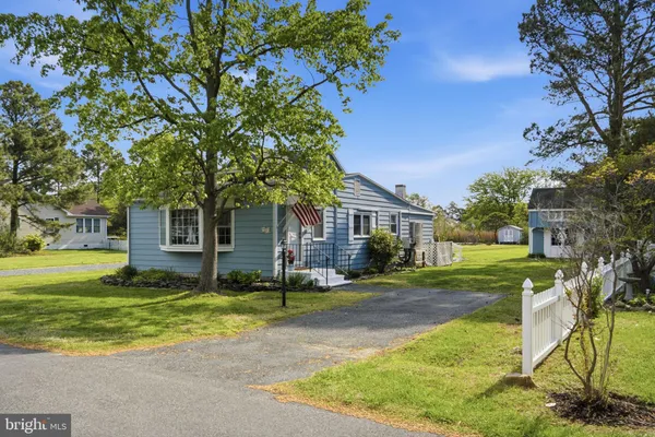 a view of a yard in front of a house with large tree