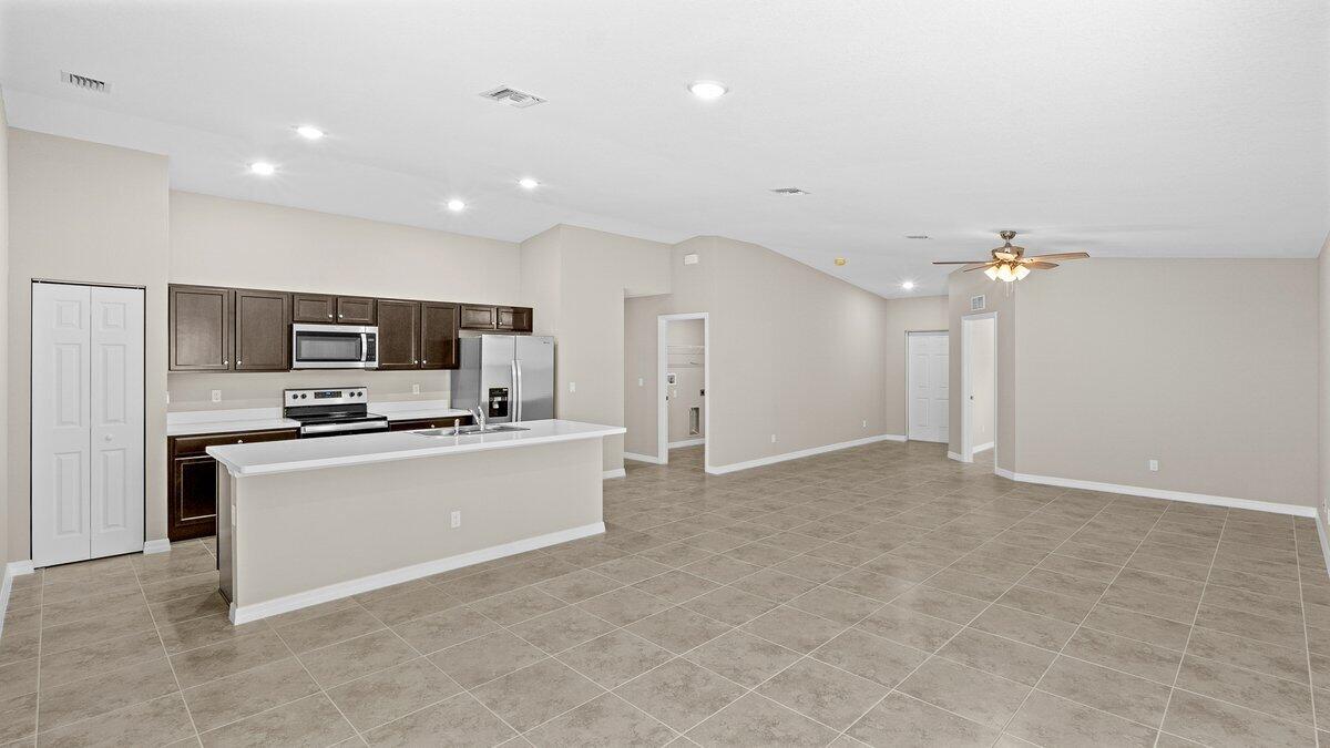 1213 Ragen Road Southeast Palm Bay, FL 32909 - Photo 8 of 26 a large kitchen with kitchen island a sink stainless steel appliances and cabinets