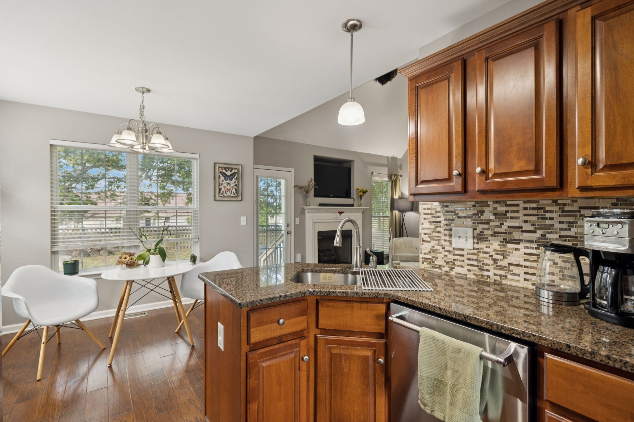 1062 Golf View Way Spring Hill, TN 37174 - Photo 19 of 42 a kitchen with granite countertop a stove a sink dishwasher a dining table and chair with wooden floor