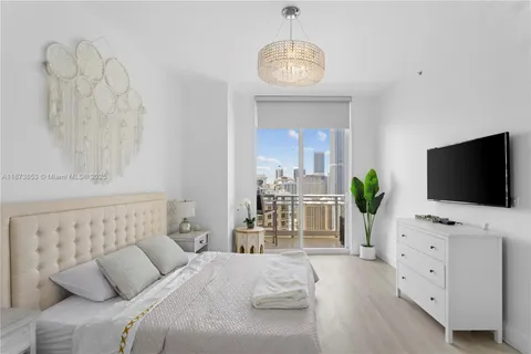 a bedroom with a bed and a flat screen tv