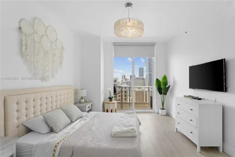 a bedroom with a bed and a flat screen tv