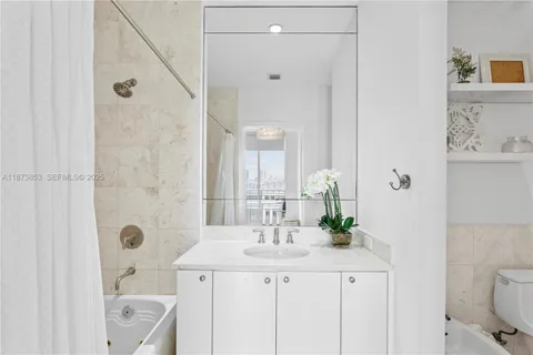 a bathroom with a granite countertop sink a toilet and shower