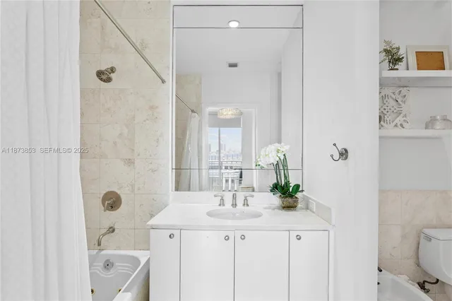 a bathroom with a granite countertop sink a toilet and shower
