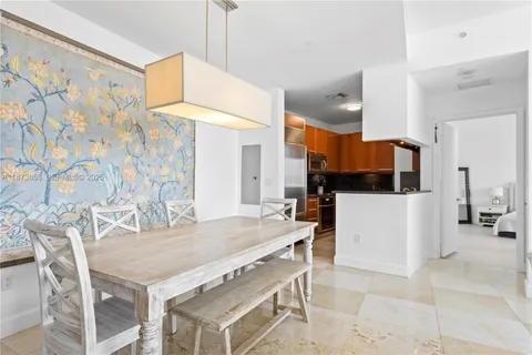 a kitchen with stainless steel appliances kitchen island granite countertop a table chairs and a refrigerator